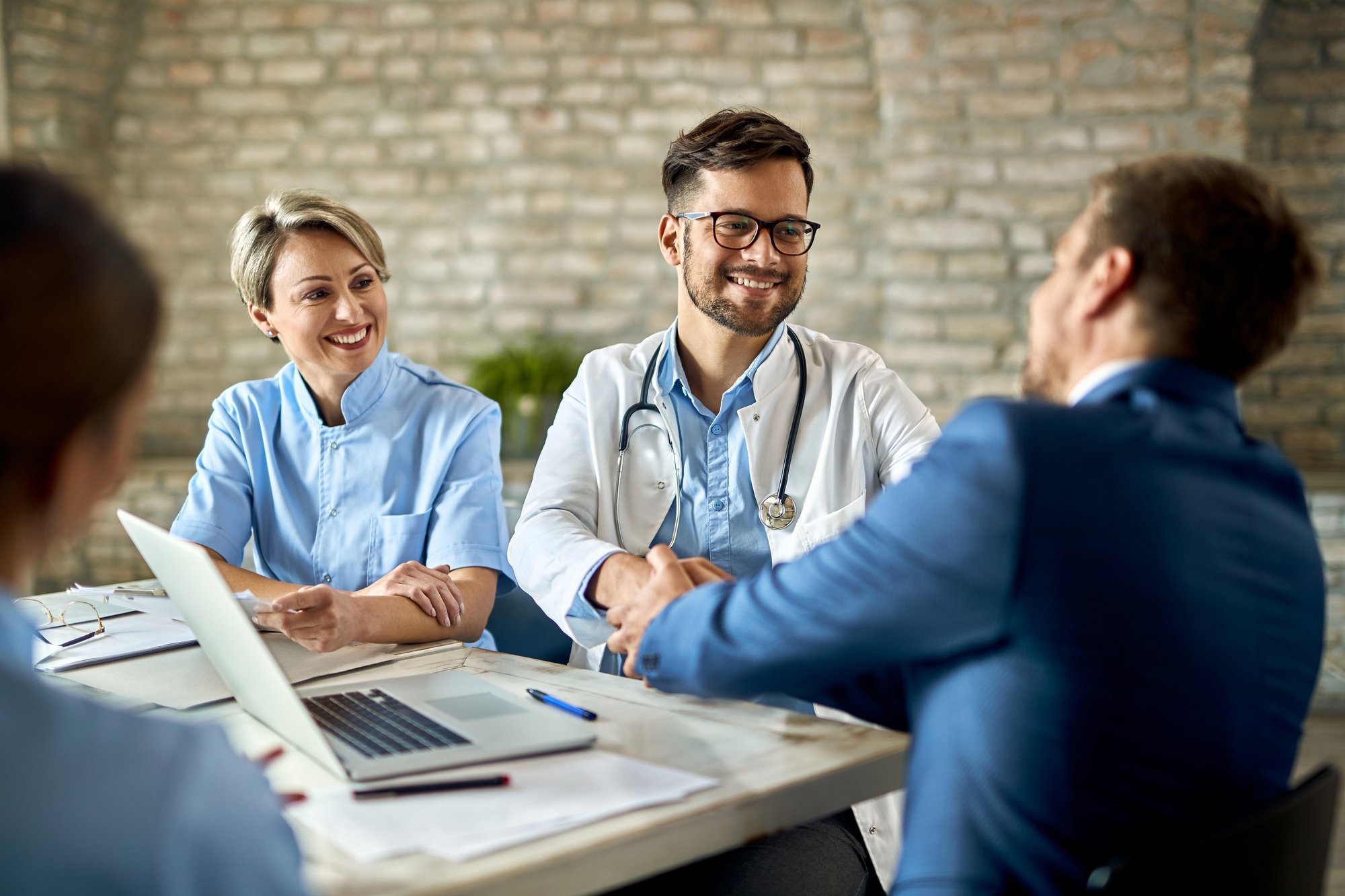 group-healthcare-workers-greeting-financial-advisor-meeting-office-focus-is-young-doctor