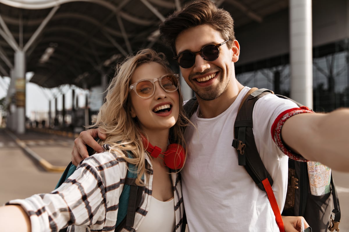 young-attractive-blonde-woman-plaid-shirt-stylish-brunette-man-sunglasses-smiles-takes-selfie-portrait-couple-travelers-near-airport young-attractive-blonde-woman-plaid-shirt-stylish-brunette-man-sunglasses-smiles-takes-selfie-portrait-couple-travelers-near-airport
